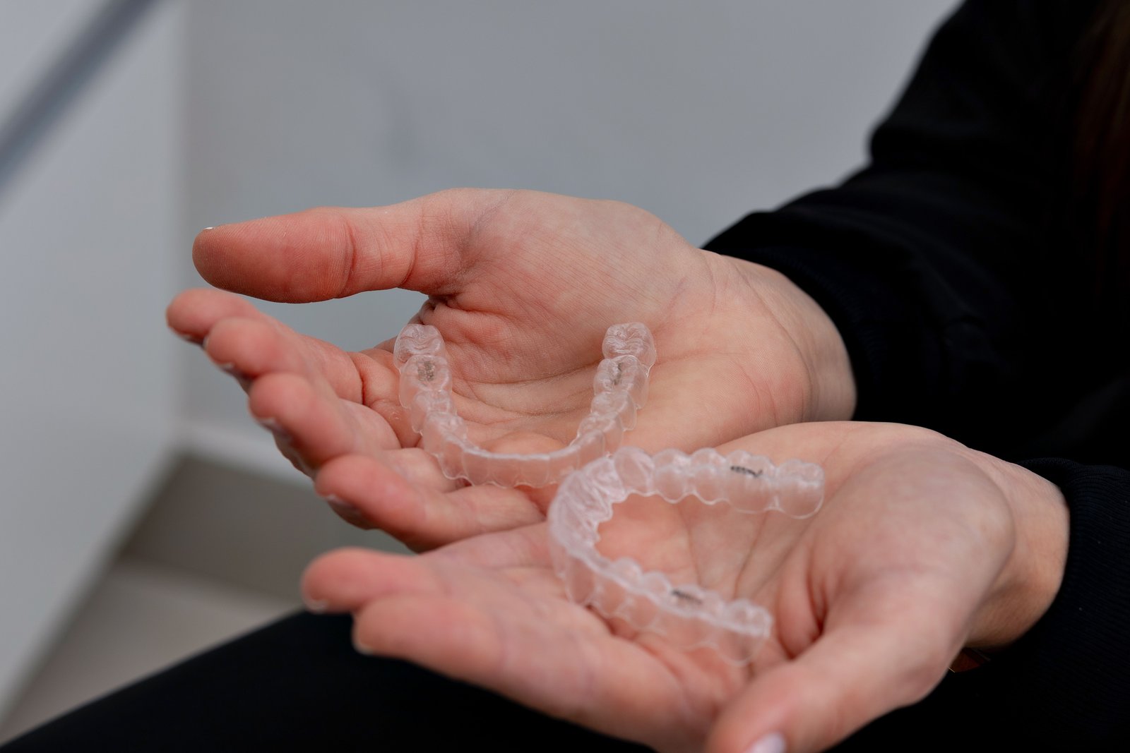 Close up of a transparent clear aligner being placed on teeth